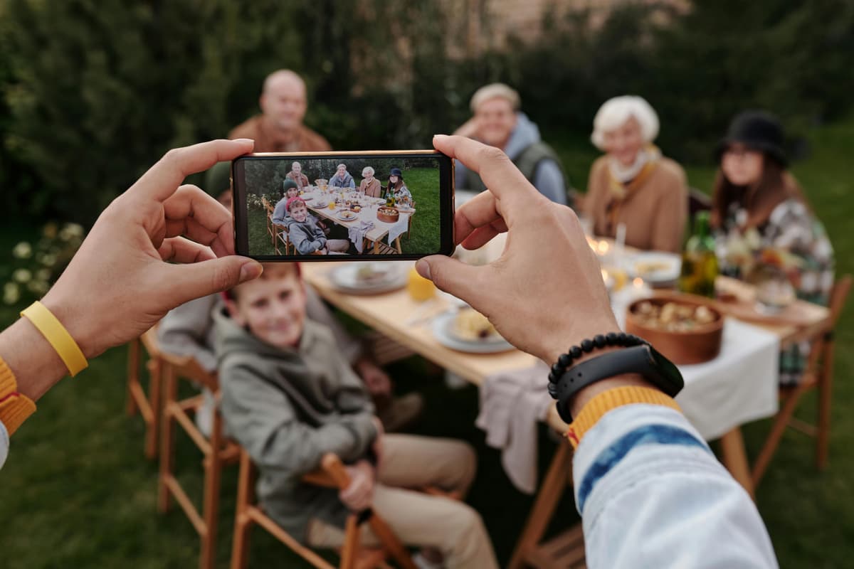 Family looking at photos on a phone while discussing privacy